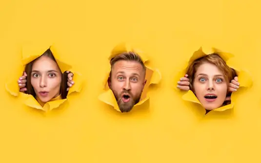 Six head breaking through yellow paper wall banner